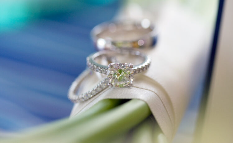 A beautiful depth of field photo of a diamond engagement ring resting on a wedding bouquet