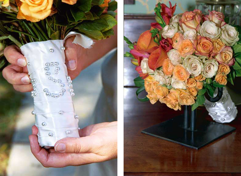 An autumn wedding bouquet consisting of cream and peach roses, as well as coral calla lilies with a pearl monogram ribbon handle.