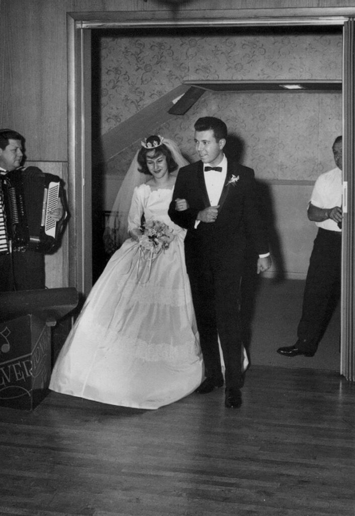 1960s bride and groom entering their wedding reception