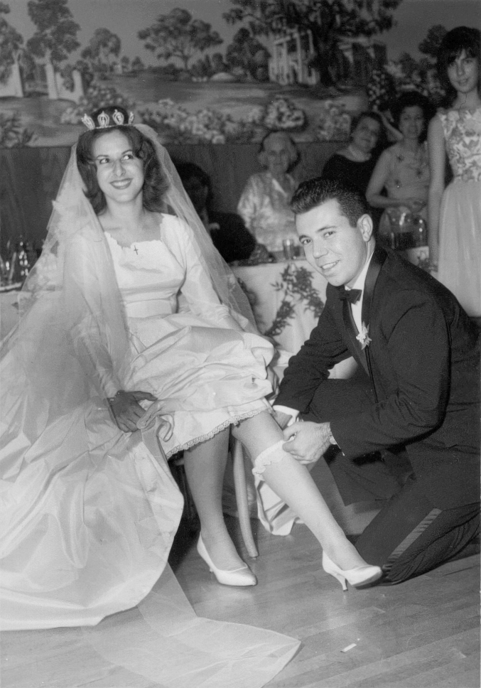 1960s bride and groom finding the garter