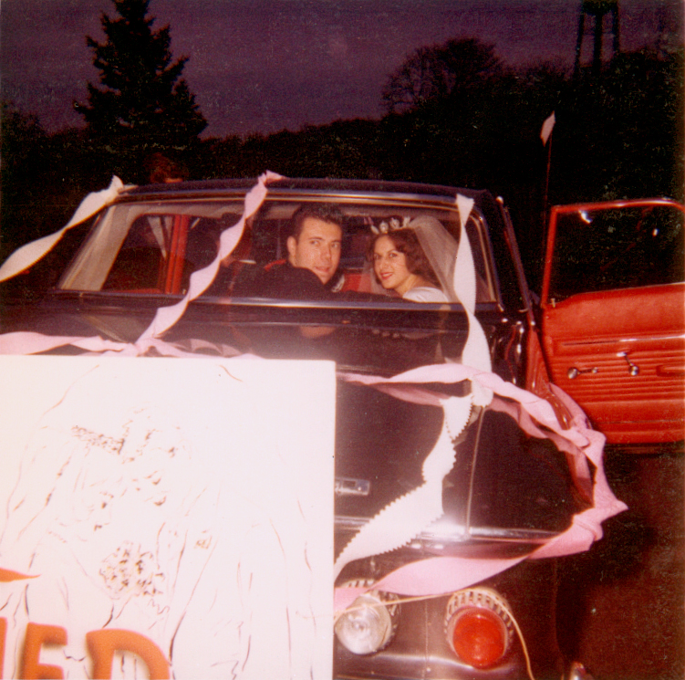 1960s bride and groom in their decorated just married car