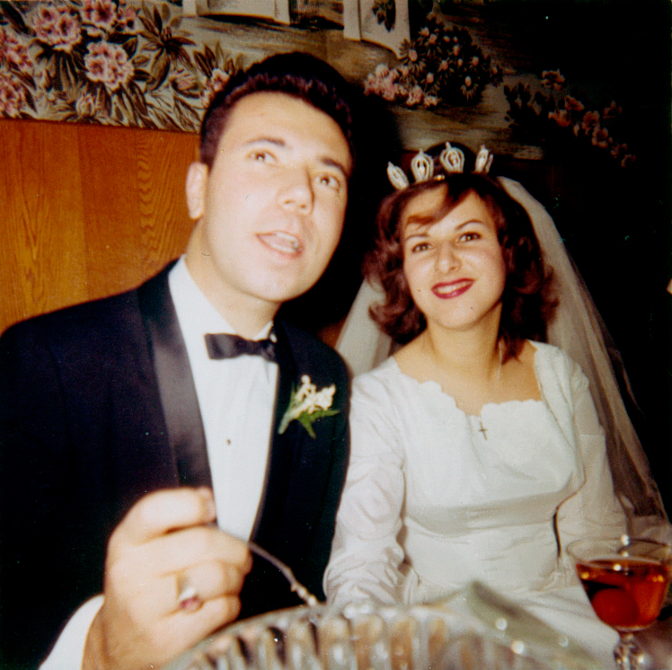 1960s bride and groom eating at their wedding reception