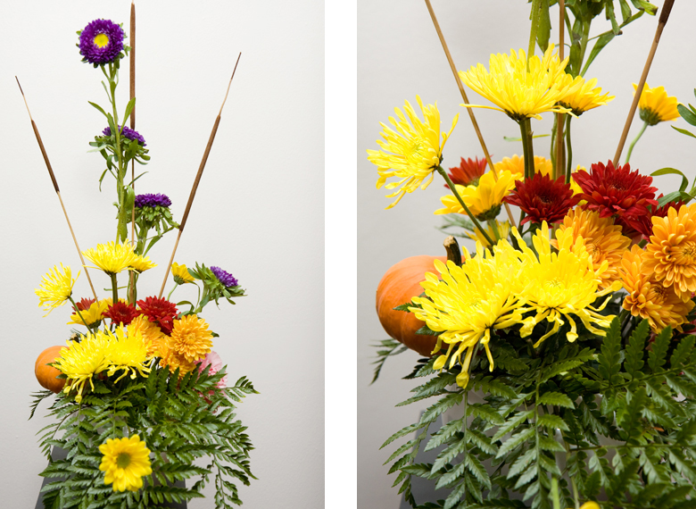 A centerpiece consisting of yellow, orange, purple and maroon chrysanthemums.